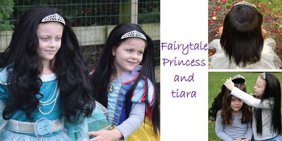 Two girls, one in a Snow White costume, Both wear My Hair Popz black princess hair which is secured to a rhinestone tiara. One girls princess dress up hair is styled straight, the other curly. An image of one girl putting wavy black princess hair on pal.