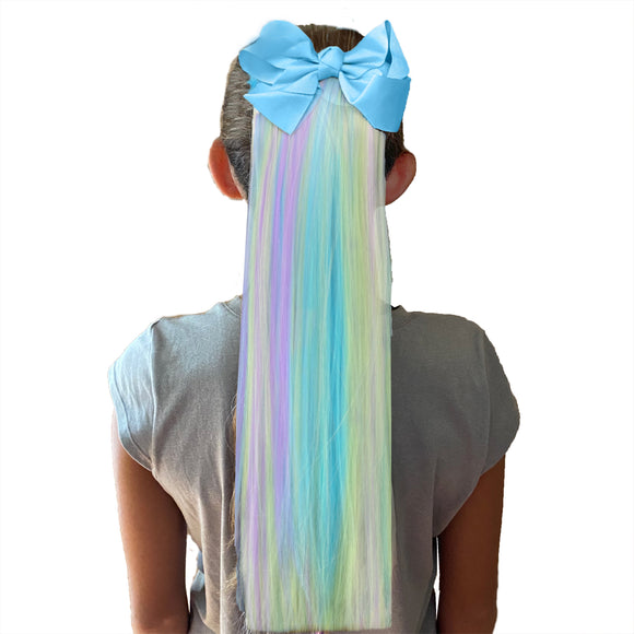 Girl wearing Unicorn color hair extensions with blue bow