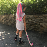 Girl wearing pink and teal hair extensions matching her field hockey uniform