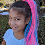Girl smiles wearing cotton candy hair extensions