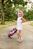 Girl posing  with fun hair extensions that match her golf bag
