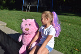 Girl wearing pink and purple hair extension ponytail to match her teddy bear